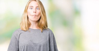 İzole arka plan yapma balık yüzüne dudaklı, çılgın ve komik bir jest büyük boy rahat t-shirt giyen güzel ve genç birbayan. Komik ifade.