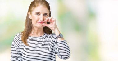 İzole arka plan ağzına kış kazak giyen orta yaş olgun güzel kadın çizgili ve parmak ile ZIP olarak Dudaklarını kapa. Gizli ve sessiz, tabu söz