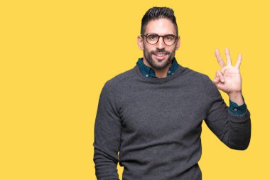Gösterilen arka plan üzerinde gözlük takan genç yakışıklı adam izole ve parmakları ile işaret üçüncü gülümseyen ise kendinden emin ve mutlu.
