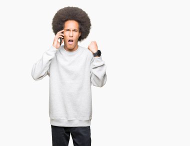 Smartphone üzerinde konuşurken afro saçlı Genç Afrikalı Amerikalı adam rahatsız ve boşa çıkarmak ile öfke, çılgın da yükseltilmiş el ile bağırmaya kavramı öfke