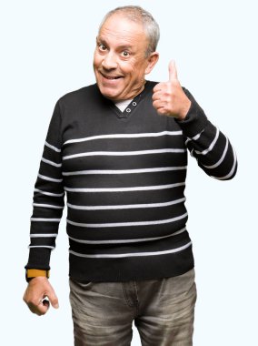 Hareketi el ile mutlu yaşasın yapıyor kış çizgili süveter giymiş yakışıklı komuta sizde. Kameraya bakarak başarı gösteren ile ifade onaylama.