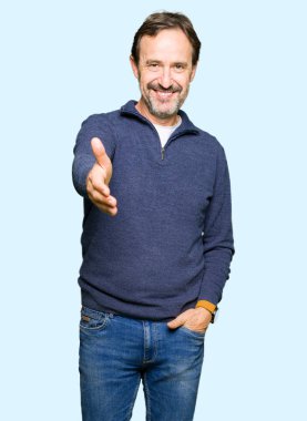 Orta yaş yakışıklı adam olarak tebrik ve konuksever dost sunan karşılıklı gülümseyen bir kazak giyiyor. Başarılı iş.