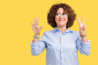 Gösterilen arka plan güzel orta ager üst düzey businees kadın üzerinde gözlük takan izole ve parmakları ile işaret kendinden emin ve mutlu gülümseyerek süre yedi numara.