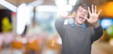 Genç yakışıklı zarif adam gösterilen ve parmakları ile işaret izole arka plan üzerinde kendinden emin ve mutlu gülümseyerek süre 6 numara.