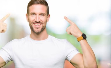 Yakışıklı adam rahat beyaz t-shirt gülen her ikisi ile baş gösteren giyen eller parmak, harika bir fikir ya da düşünce, iyi hafıza