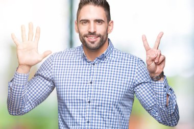Yakışıklı delikanlı gösterilen ve parmakları ile işaret izole arka plan üzerinde kendinden emin ve mutlu gülümseyerek süre yedi numara.