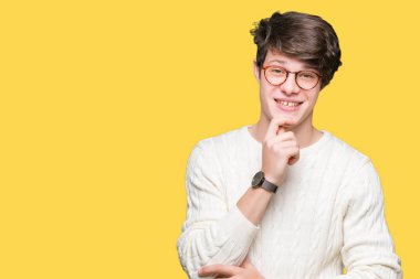 Emin çapraz kollar ve çeneme kaldırdı el ile gülümseme ile kameraya bakarak izole arka plan üzerinde gözlük takan yakışıklı delikanlı. Pozitif düşünce.