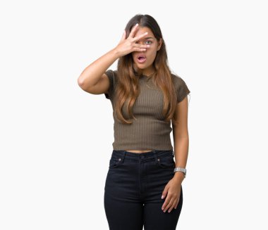 Yüz ve gözler el ile kapsayan şok bakmak izole arka plan üzerinde genç güzel esmer kadın mahcup ifadeyle parmaklarımın arasından arıyorsunuz.