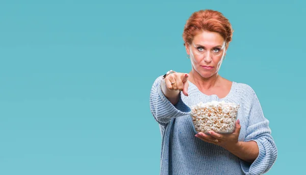 Atrractive Senior Caucasian Redhead Woman Eating Popcorn Isolated Background Pointing — Stock Photo, Image