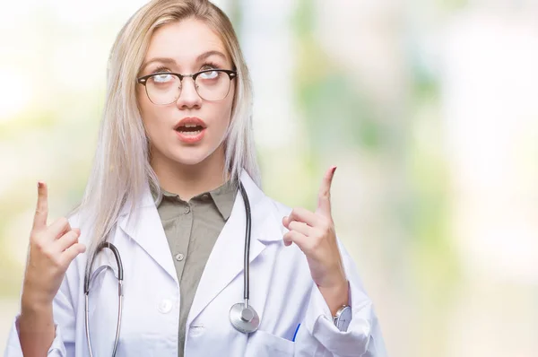 Giovane Donna Medico Bionda Sfondo Isolato Stupito Sorpreso Guardando Alto — Foto Stock