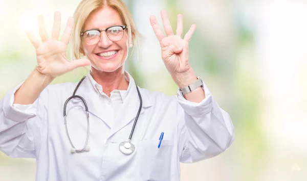 中年金发医生妇女超过孤立背景显示和指向与手指数字九同时微笑自信和快乐 — 图库照片