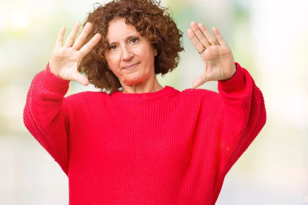 美丽的中间年龄的老年妇女红色冬天毛衣在孤立的背景微笑做框架使用手手掌和手指 照相机透视 — 图库照片
