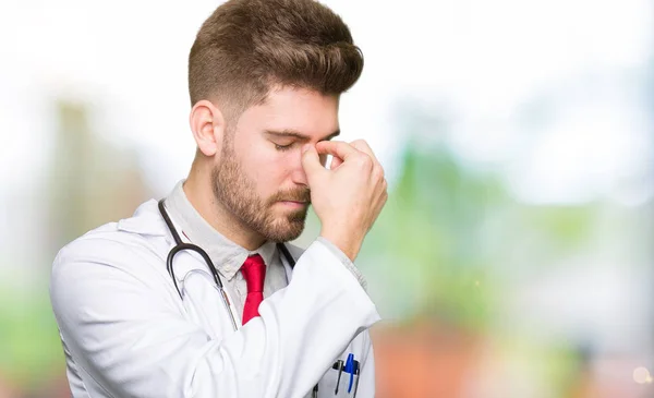 Young Handsome Doctor Man Wearing Medical Coat Tired Rubbing Nose — Stock Photo, Image