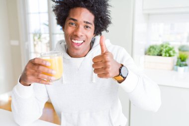 Basılı tutup ok işareti, başparmak ile parmak, mükemmel işareti yapıyor kocaman bir gülümseme ile portakal suyu mutlu bardak içme Afrikalı-Amerikalı adam