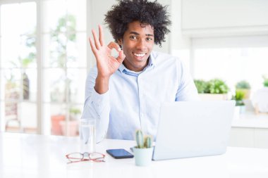 Afrika kökenli Amerikalı iş adamı parmak, mükemmel sembolü ile ok işareti yapıyor dizüstü kullanarak çalışma
