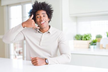 Afro-Amerikan erkek ev gülümseyen el ve parmak telefonda konuşmak ile telefon jest yapıyor. Kavramları iletişim.