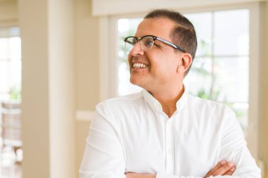 Evde kameraya gülümseyen gözlük takan orta yaş erkek