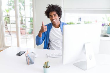Afro-Amerikan erkek hareketi el ile mutlu Yaşasın yapıyor bilgisayarla çalışma. Kameraya bakarak başarı gösteren ile ifade onaylama.