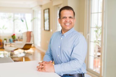 Orta yaş erkek fotoğraf makinesi için evde emin gülümseyen