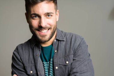 Yakışıklı delikanlı possing ve modelleme gri izole arka plan üzerinde