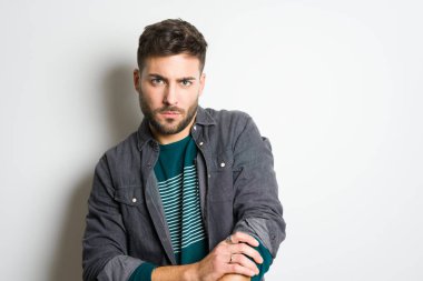 Yakışıklı delikanlı possing ve modelleme gri izole arka plan üzerinde