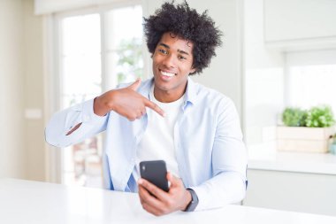 Afrika kökenli Amerikalı adam kendisi için sürpriz yüz işaret parmağı ile Smartphone kullanarak