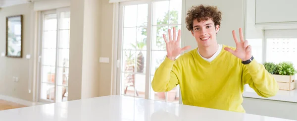 在脸上自信快乐的时候 年轻帅哥在家里展示和指着八号手指的广角镜头 — 图库照片