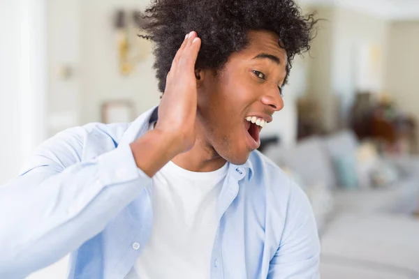 Uomo Afroamericano Casa Sorridente Con Mano Sull Orecchio Ascoltando Voci — Foto Stock