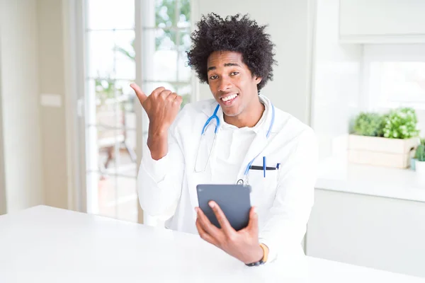 Афроамериканец Таблеткой Указывает Клинику Показывает Пальцем Вверх Сторону Счастливым Лицом — стоковое фото