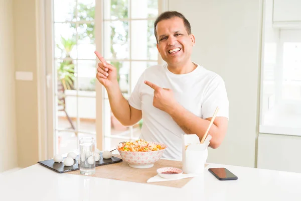 Hombre Mediana Edad Comiendo Comida Asiática Con Palillos Casa Sonriendo — Foto de Stock
