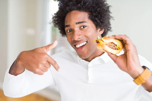 Hombre Afroamericano Hambriento Comiendo Hamburguesa Para Almuerzo Con Cara Sorpresa — Foto de Stock