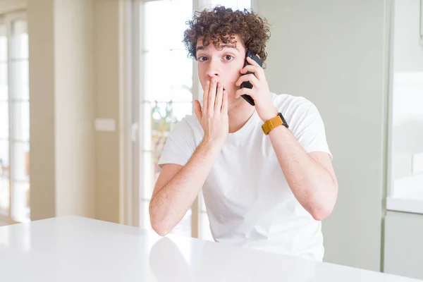 Νεαρός Άνδρας Που Μιλάτε Στο Τηλέφωνο Στο Σπίτι Κάλυμμα Στόματος — Φωτογραφία Αρχείου