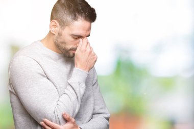 Genç yakışıklı adam izole arka plan üzerinde yorgun gözleri duygu yorgunluk ve baş ağrısı ve burun sürtme kazak giyiyor. Stres ve hayal kırıklığı kavramı.