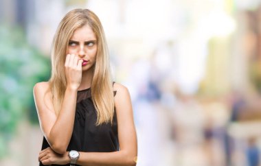 Genç güzel sarışın ve mavi gözlü kadın yüzünden stresli ve gergin elle çivi ısırma ağzına bakarak izole arka plan. Anksiyete sorunu.