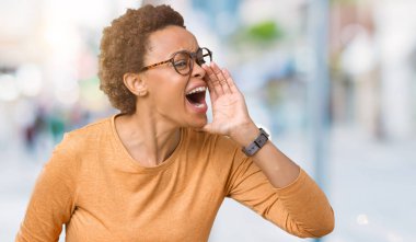 Bağırarak ve ağzı üzerinde el ile yan için çığlık izole arka plan üzerinde gözlük takan genç güzel Afrikalı-Amerikalı kadın. İletişim kavramı.