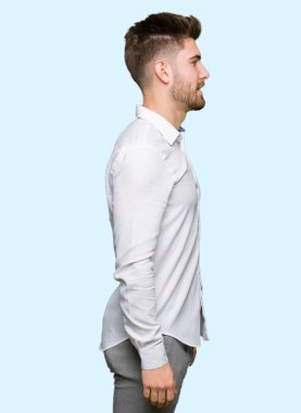 Genç yakışıklı iş adamı tarafına, seyir dinlenmek doğal yüz emin gülümseme ile pozuyla profil.