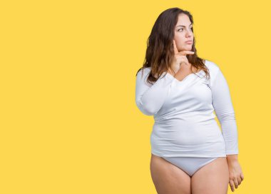 Beautiful plus size young overwight woman wearing white underwear over isolated background with hand on chin thinking about question, pensive expression. Smiling with thoughtful face. Doubt concept. clipart