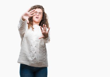 Şokta bağırarak korkuyor ve dehşet korku ifade dur hareketi el ile ile izole arka plan üzerinde kış kazak giyen güzel esmer kıvırcık saçlı Genç kız. Panik kavramı.