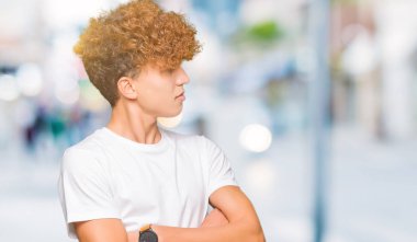 Gülümseyen geçti silah ile ikna yan seyir ve kendine güvenen rahat beyaz t-shirt giyen afro saçlı Genç yakışıklı adam