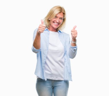 Orta yaş sarışın kadın el ile pozitif jest yapıyor onaylama izole arka plan üzerinde başparmak gülümseyen ve başarı için mutlu. Kamera, kazanan jest arıyorsunuz.