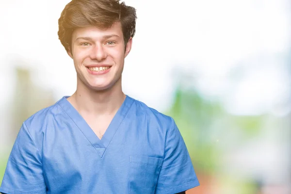 若い医者の顔に幸せとクールな笑顔で孤立した背景に医療制服を着てします 幸運な人 — ストック写真