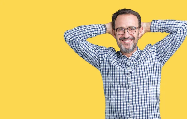 Yakışıklı orta yaş zarif komuta sizde gözlük izole üzerinde arka plan dinlenirken ve germe kollar ve eller baş ve boyun arkasında ile mutlu gülümseyerek