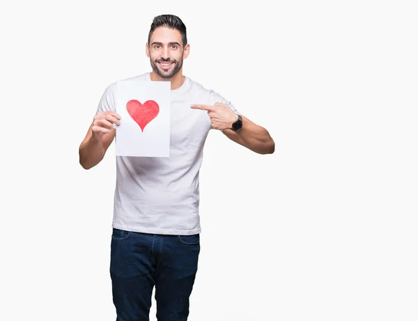 Guapo Joven Sosteniendo Tarjeta Con Corazón Rojo Sobre Fondo Aislado — Foto de Stock