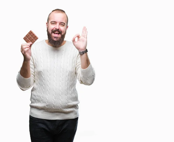 Jonge Hipster Man Eten Chocoladereep Geïsoleerde Achtergrond Doen Teken Met — Stockfoto