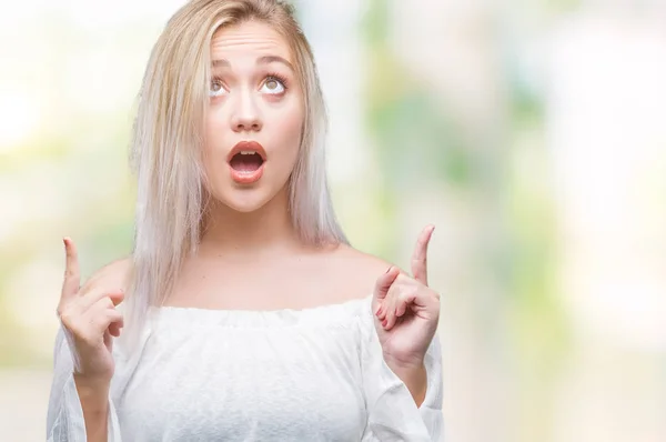 Young Blonde Woman Isolated Background Amazed Surprised Looking Pointing Fingers — Stock Photo, Image