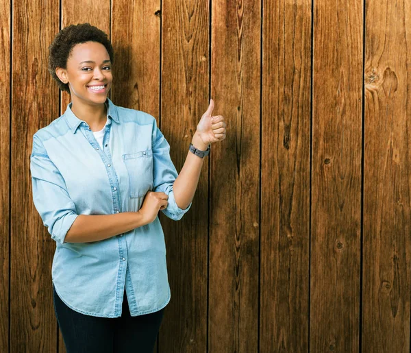 Yanına bir jest yapıyorsun gülümseyen genç güzel Afrikalı-Amerikalı kadın izole arka plan gurur, seyir yaşasın