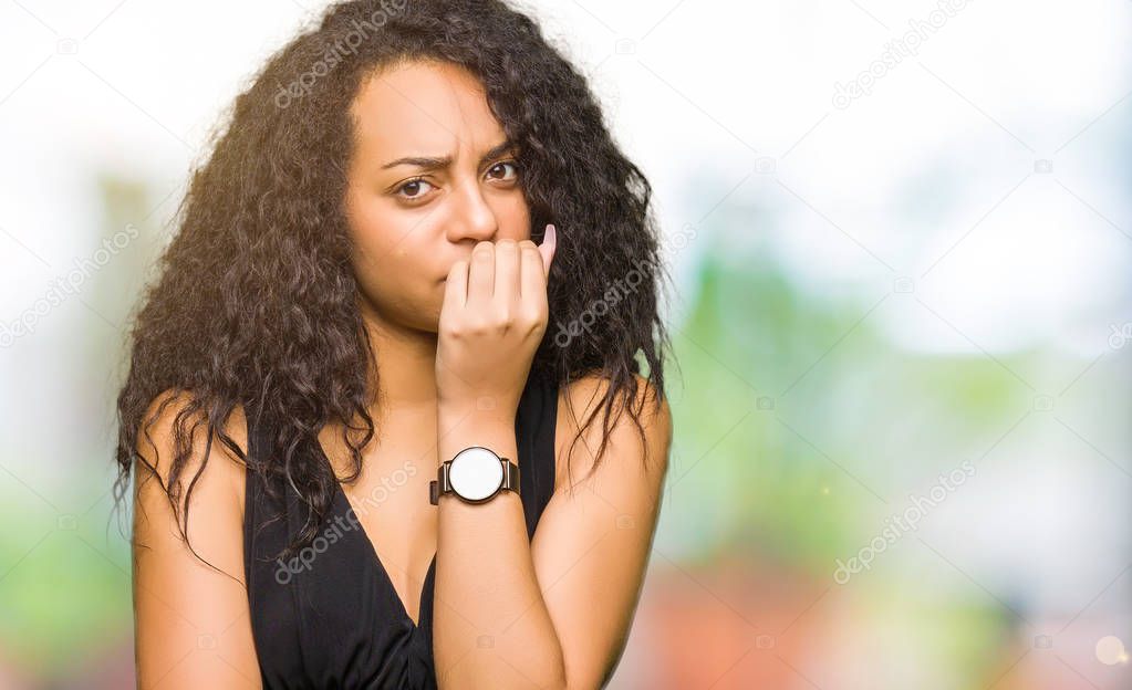 Young beautiful girl with curly hair wearing fashion skirt looking stressed and nervous with hands on mouth biting nails. Anxiety problem.