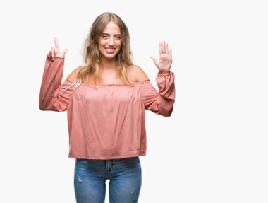 Gösterilen ve parmakları ile işaret izole arka plan üzerinde sarışın güzel genç kadın kendinden emin ve mutlu gülümseyerek süre yedi numara.