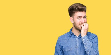 Genç yakışıklı sarışın adam stresli ve gergin ile rahat kot gömlek giymiş tırnak ısırma dudaklarından eller. Anksiyete sorunu.