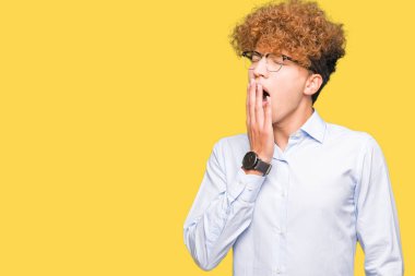 Afro giyen gözlük sıkılmış esneme ile genç yakışıklı iş adamı el ağzıyla kapsayan yorgun. Restless ve uyku hali.